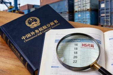 China HS tariff code reference book with magnifying glass on customs classification page